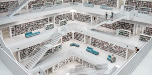 Grand escalier ouvert sur les rayonnages d'une bibliothèque entièrement blanche